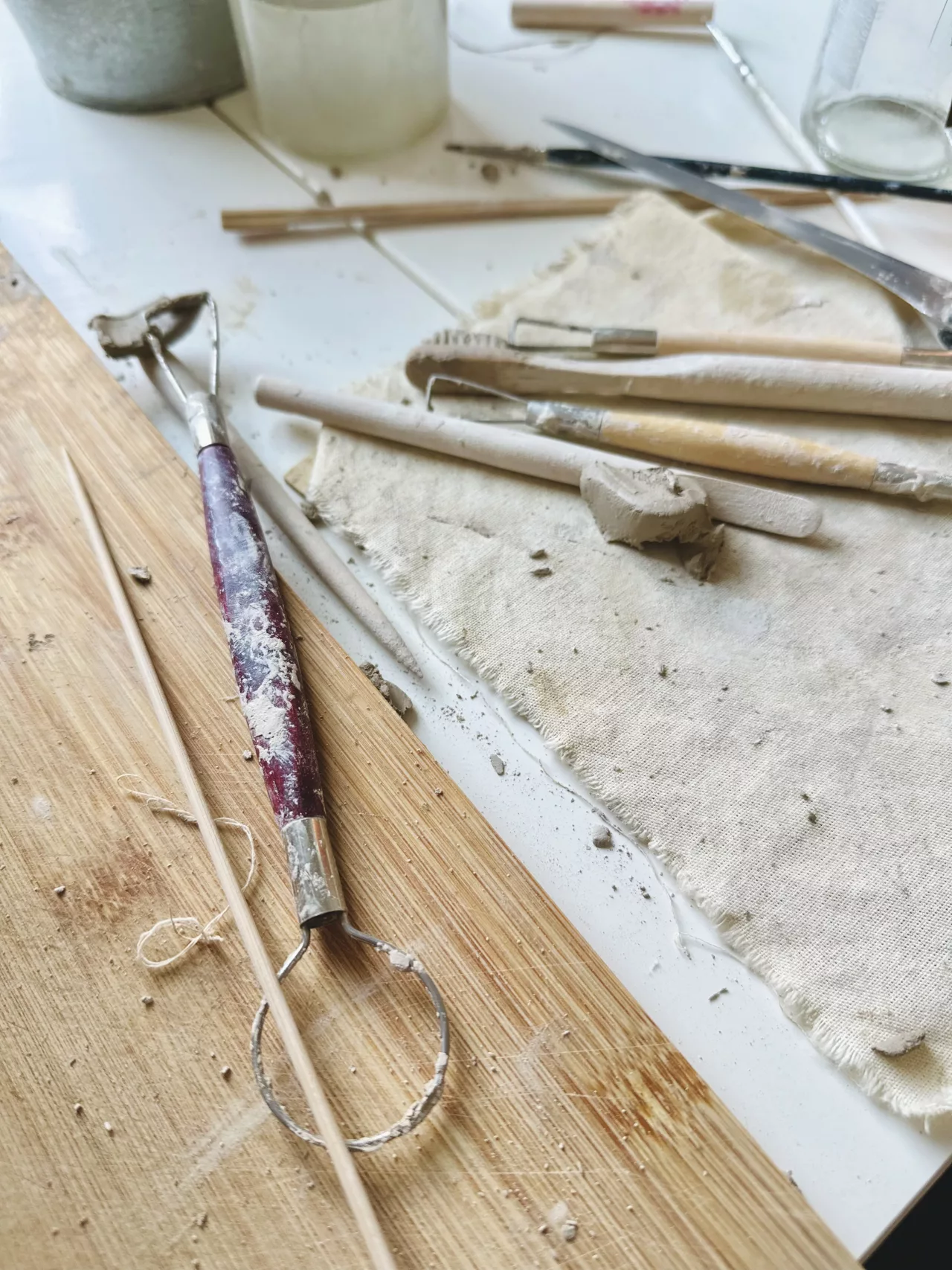 Narzędzia ceramiczne i kawałki gliny na stole w pracowni