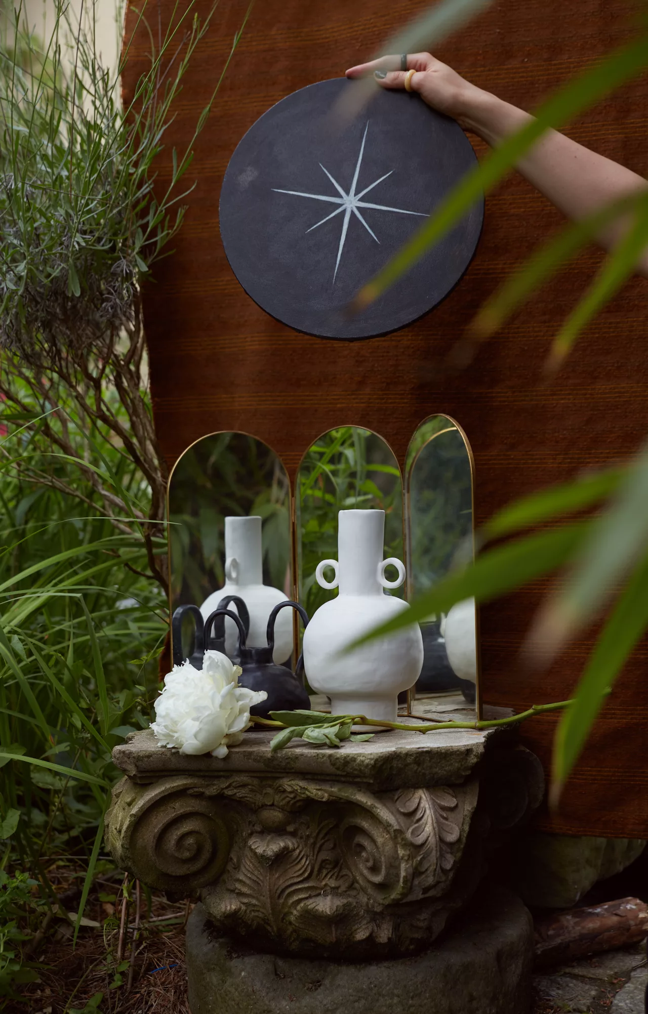 Czarno-białe ceramiczne wazony z lustrami i białym kwiatem w ogrodzie